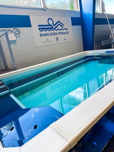 A small pool with a sign hanging next to it that reads Endless Pool.