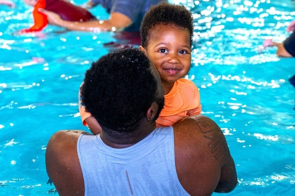 A father carries his young son in the water during a swim lesson at RAFC.