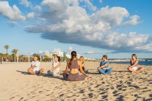 A group of people practicing yoga on a beach