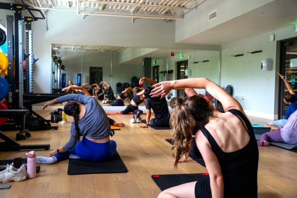 A group of people stretching during a mat Pilates class at RAFC. 