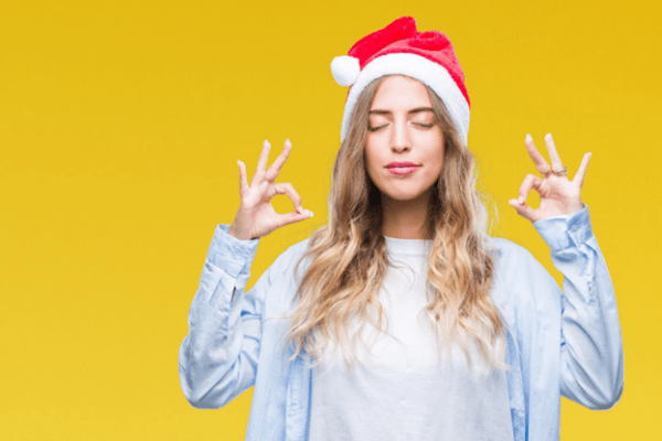 A woman wearing a Santa hat practicing mindfulness techniques.