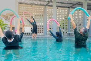 An engaging aquatic exercise class for seniors led by an instructor in a pool.