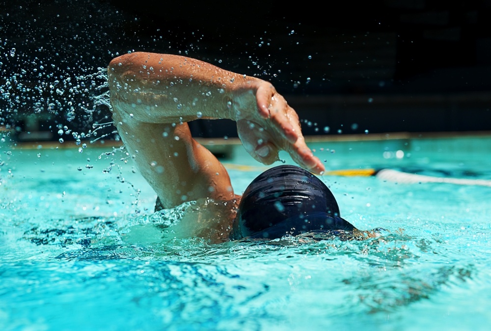 A man mid-stroke while lap swimming.