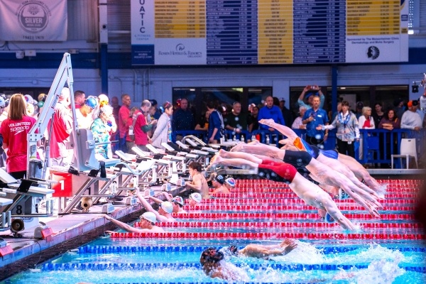 Several swimmers dive into the water during a relay at RAFC.