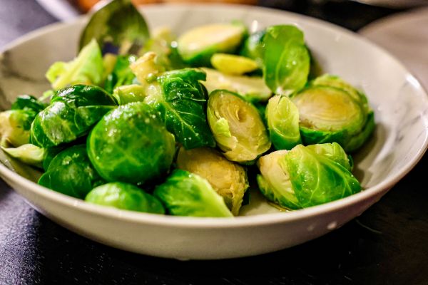 Homemade steamed brussels sprouts served in a white bowl.